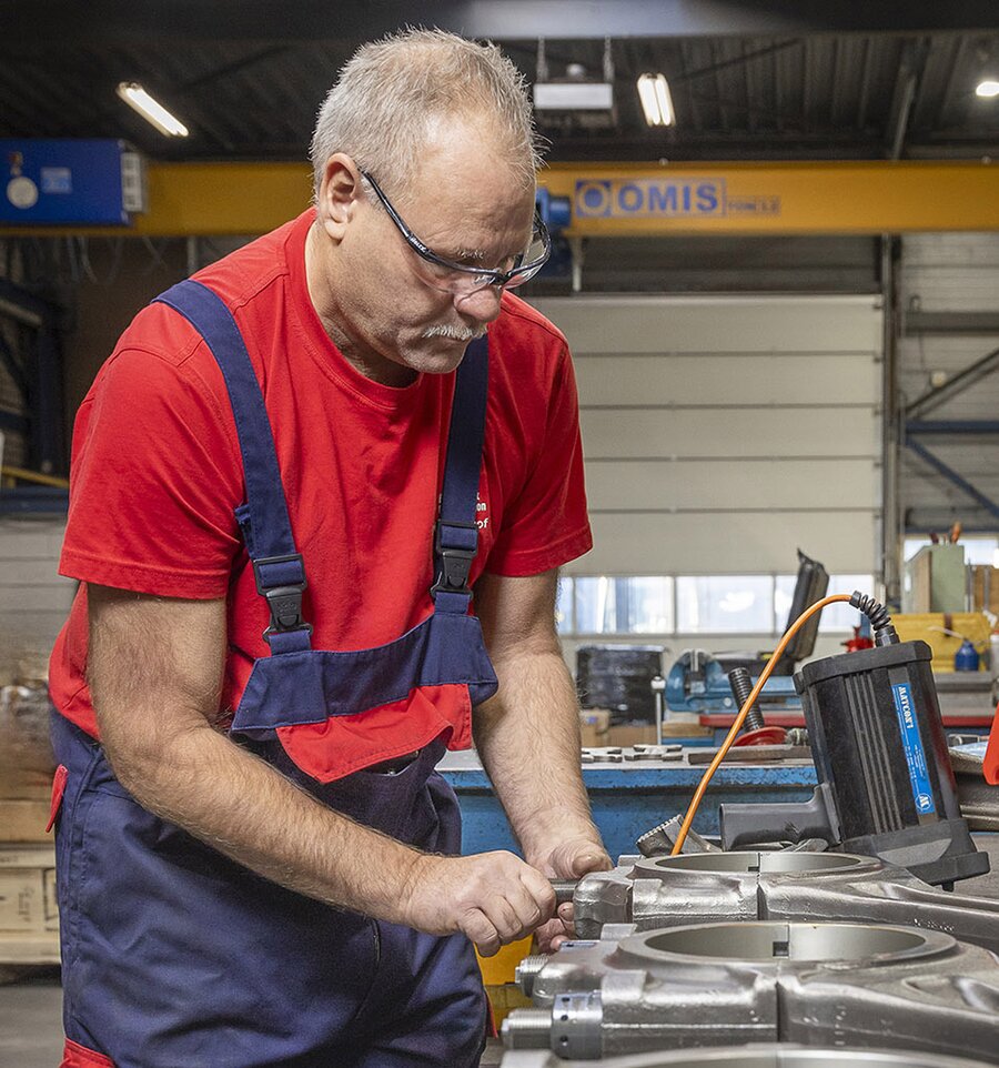 Local Burckhardt Compression field service representative during a detailed on-site inspection.