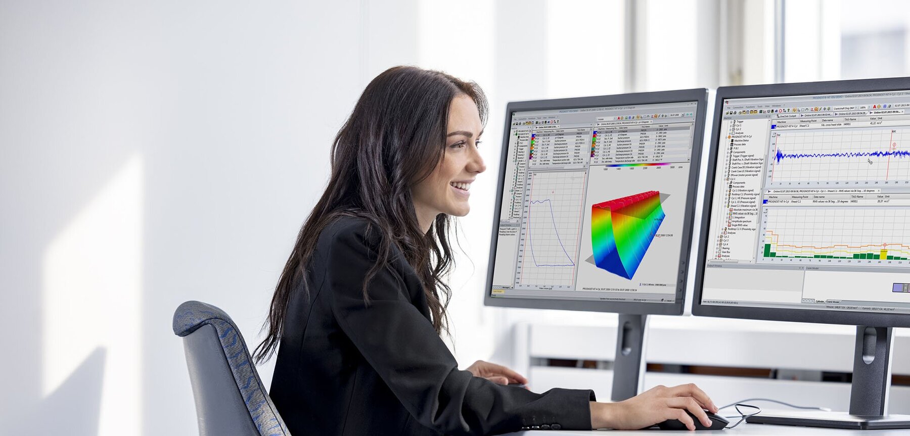 Young woman sitting in front of screens