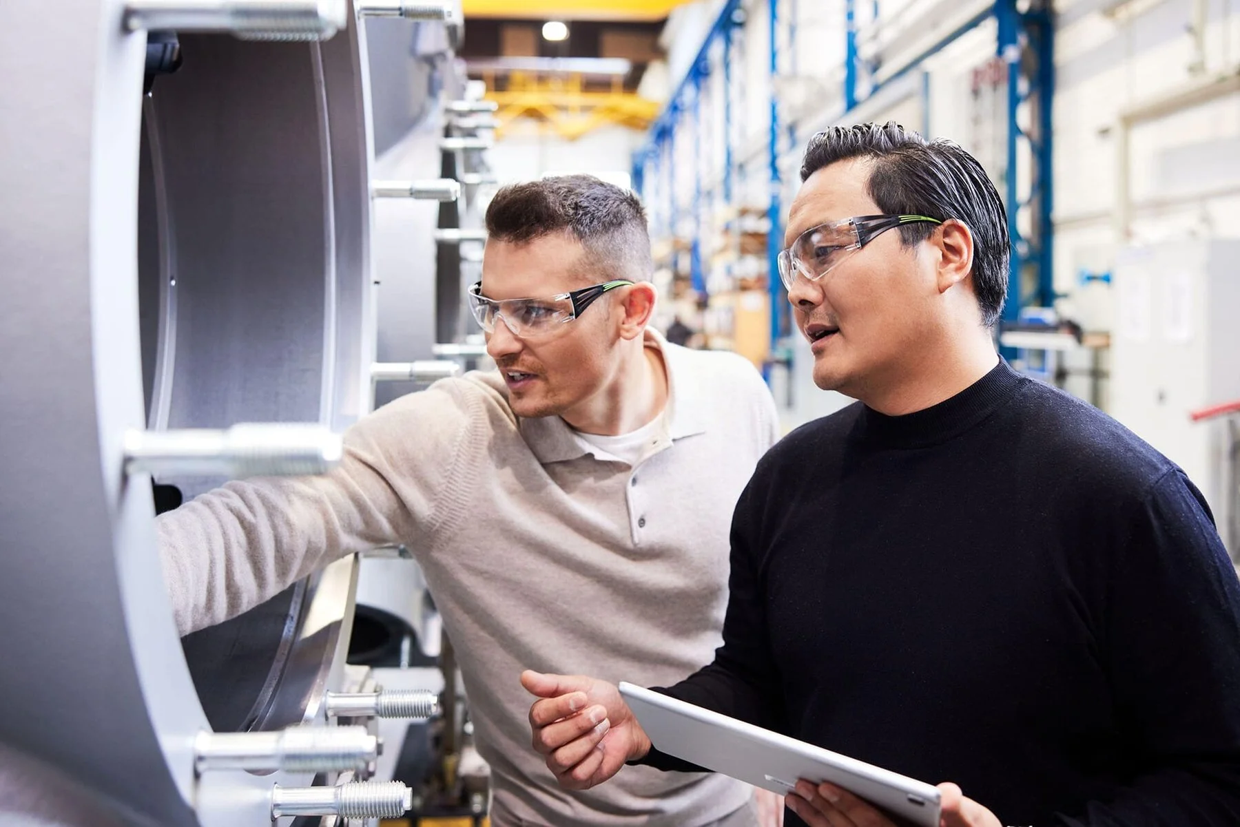 Two people at workshop checking machine quality
