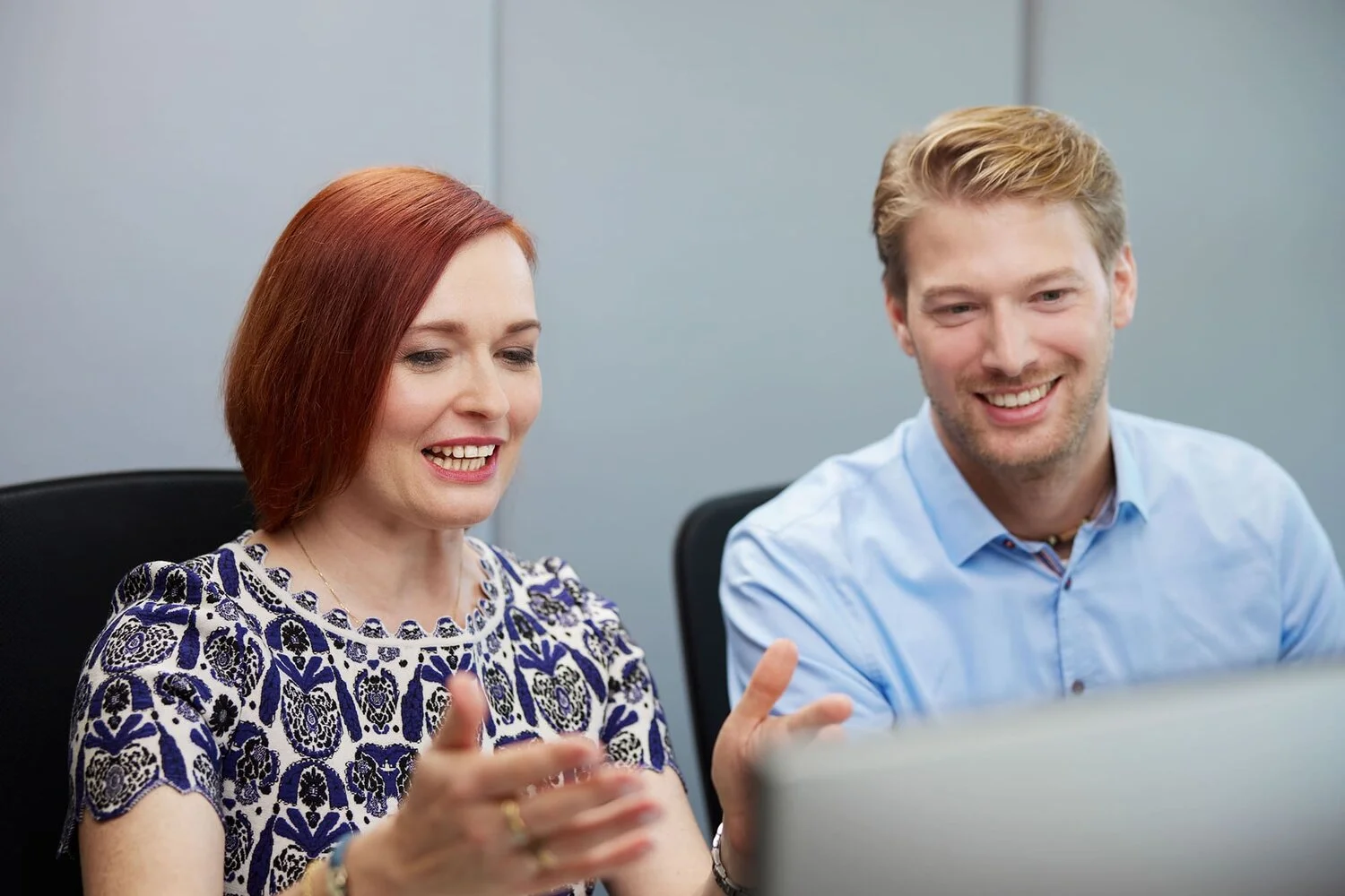 Two people discussing something looking at a screen in an office