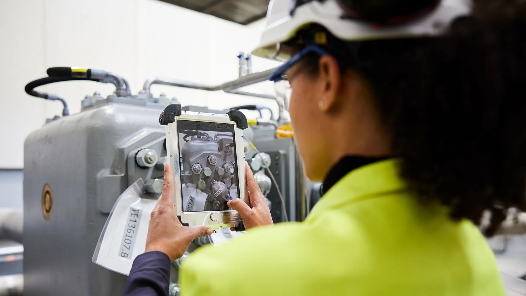 Woman with iPad in front of compressor