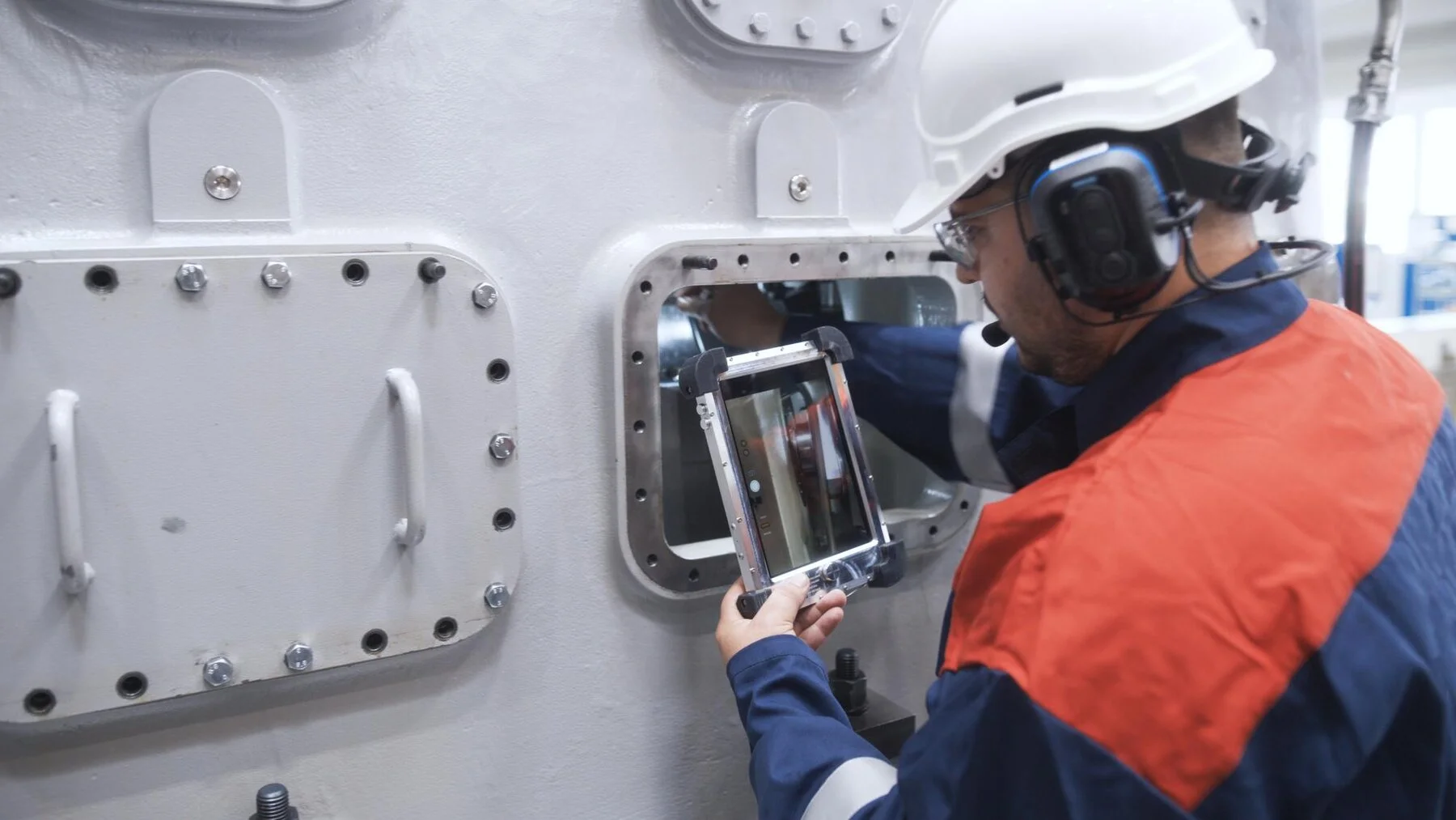 Technician with tablet servicing compressor parts on site