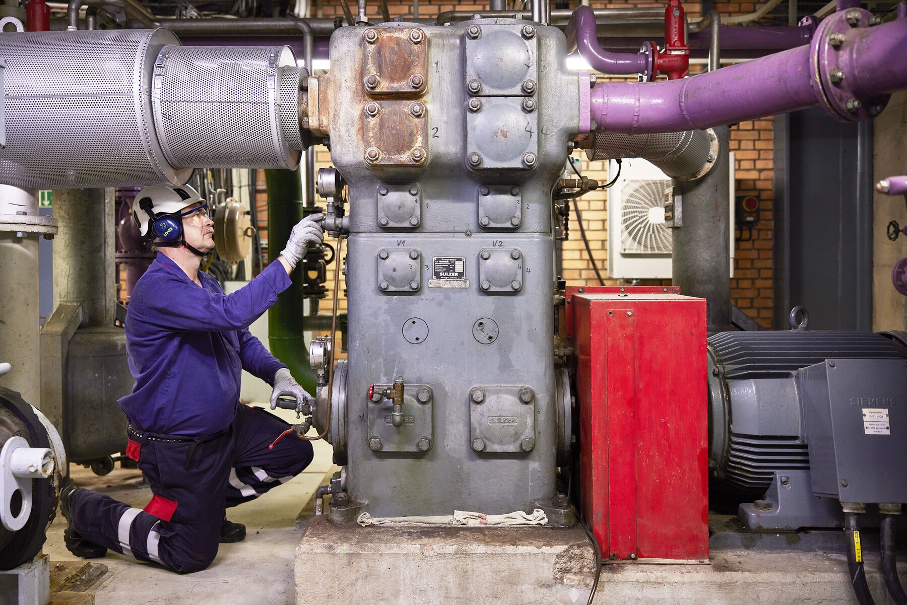 Expert inspecting compressor at customer site