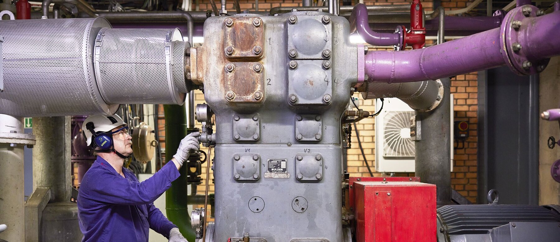 Expert inspecting compressor at customer site
