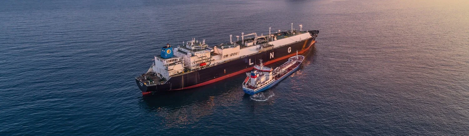 LNG tanker on sea next to tuckboat