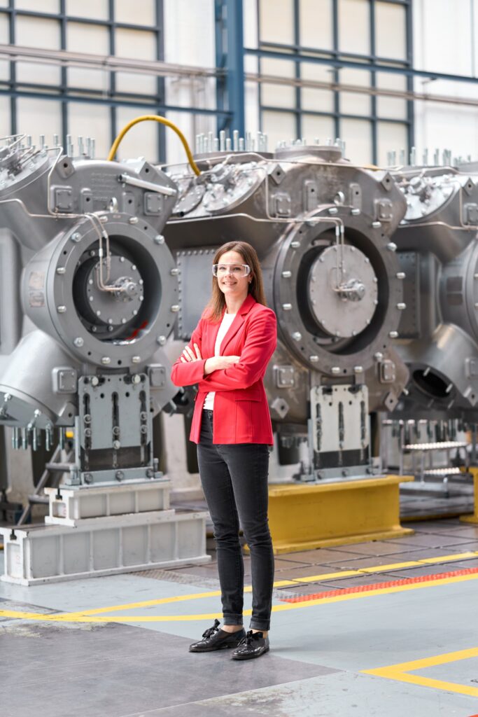 Hydrogen Mobility & Energy Leader standing near Compressor