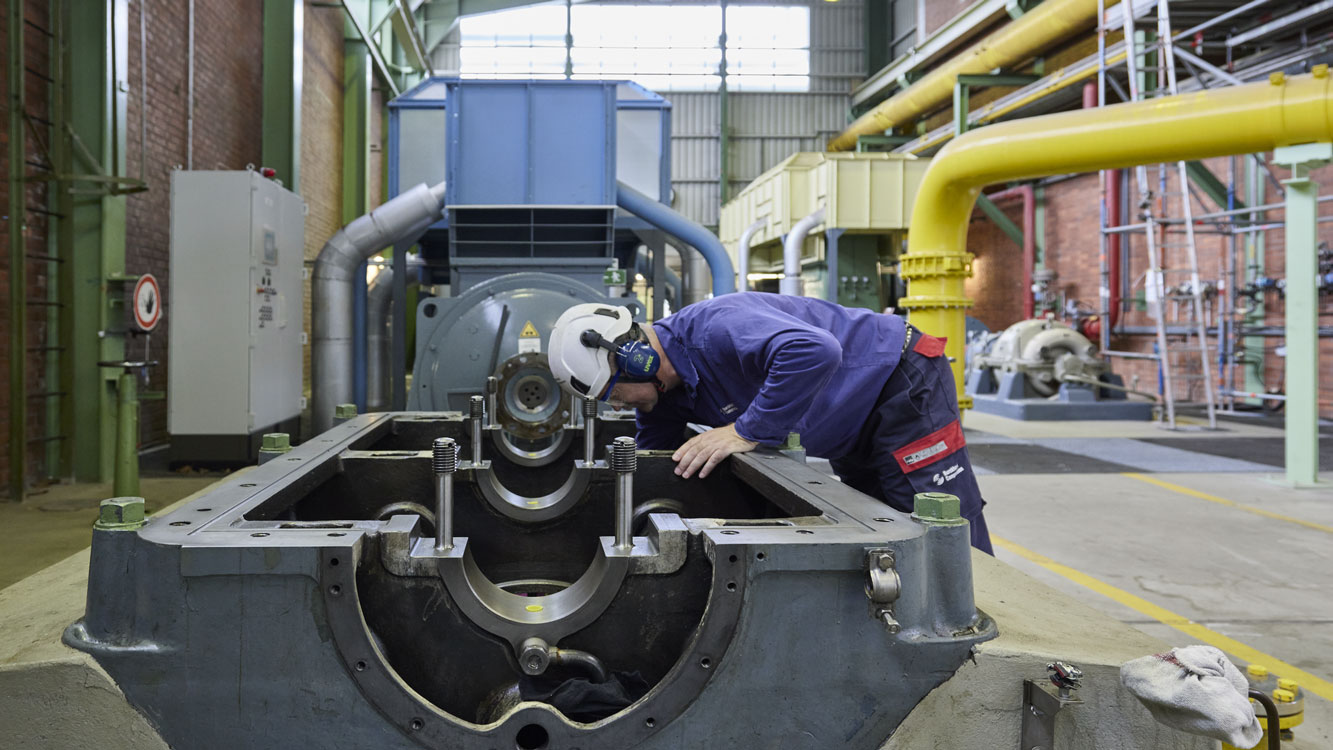 Filed service repair man looking into compressor